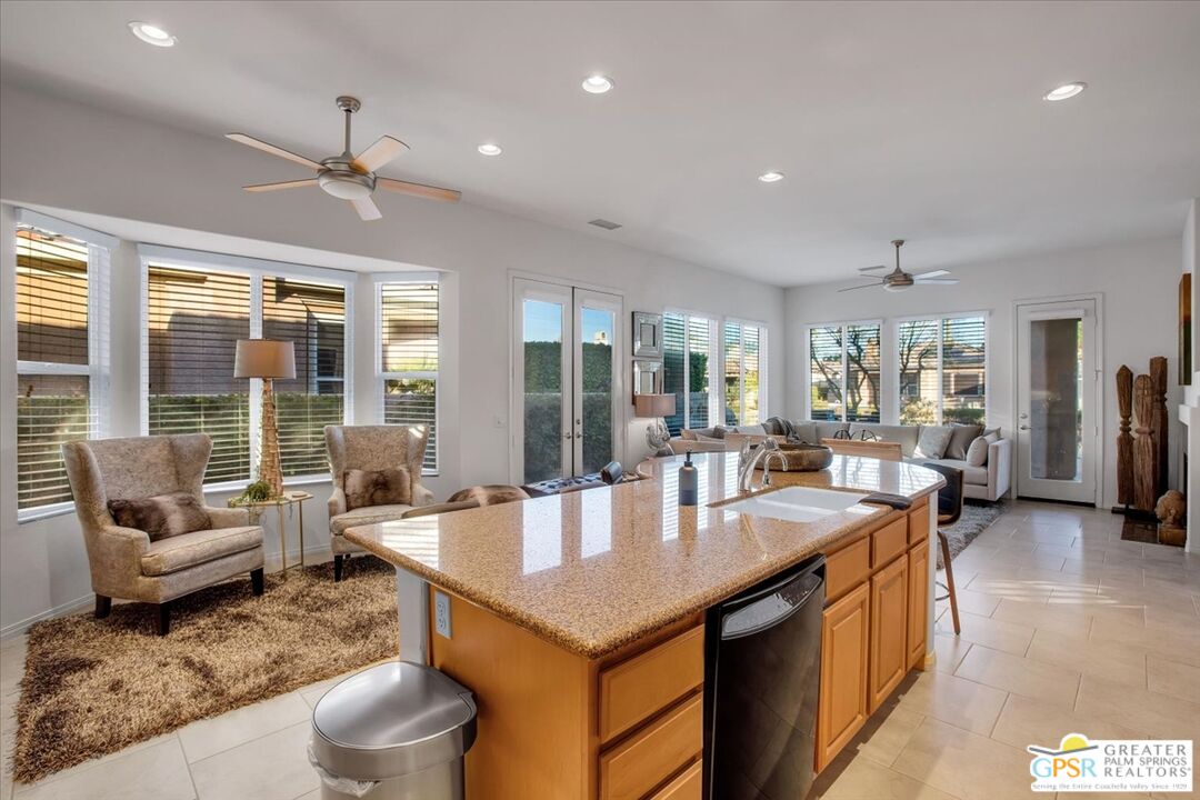 8 Lake Como Court Rancho Mirage, CA 92270 - Photo 16 of 63 a dining hall with stainless steel appliances granite countertop a table chairs and a living room