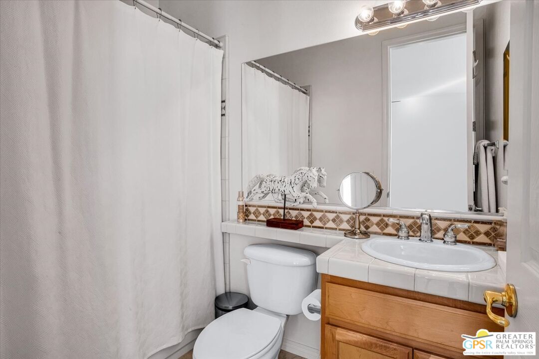 8 Lake Como Court Rancho Mirage, CA 92270 - Photo 9 of 63 a bathroom with a granite countertop sink and a mirror