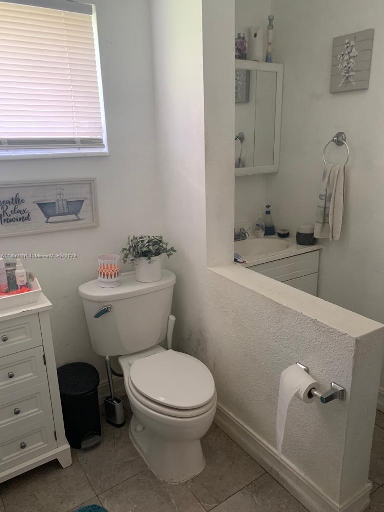 506 Jersey Road West Lehigh Acres, FL 33936 - Photo 4 of 10 a bathroom with a toilet a sink and a window