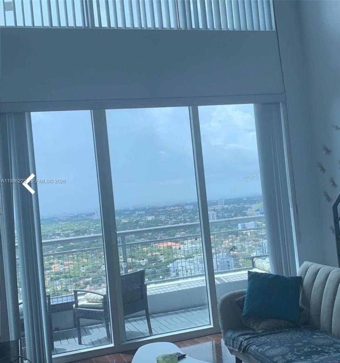 60 Southwest 13th Street, Unit 3017 Miami, FL 33130 - Photo 13 of 46 a living room with a floor to ceiling window