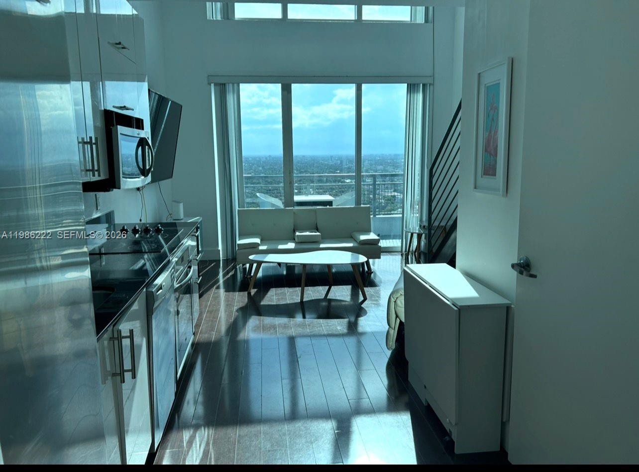 60 Southwest 13th Street, Unit 3017 Miami, FL 33130 - Photo 17 of 46 a living room with furniture and a floor to ceiling window