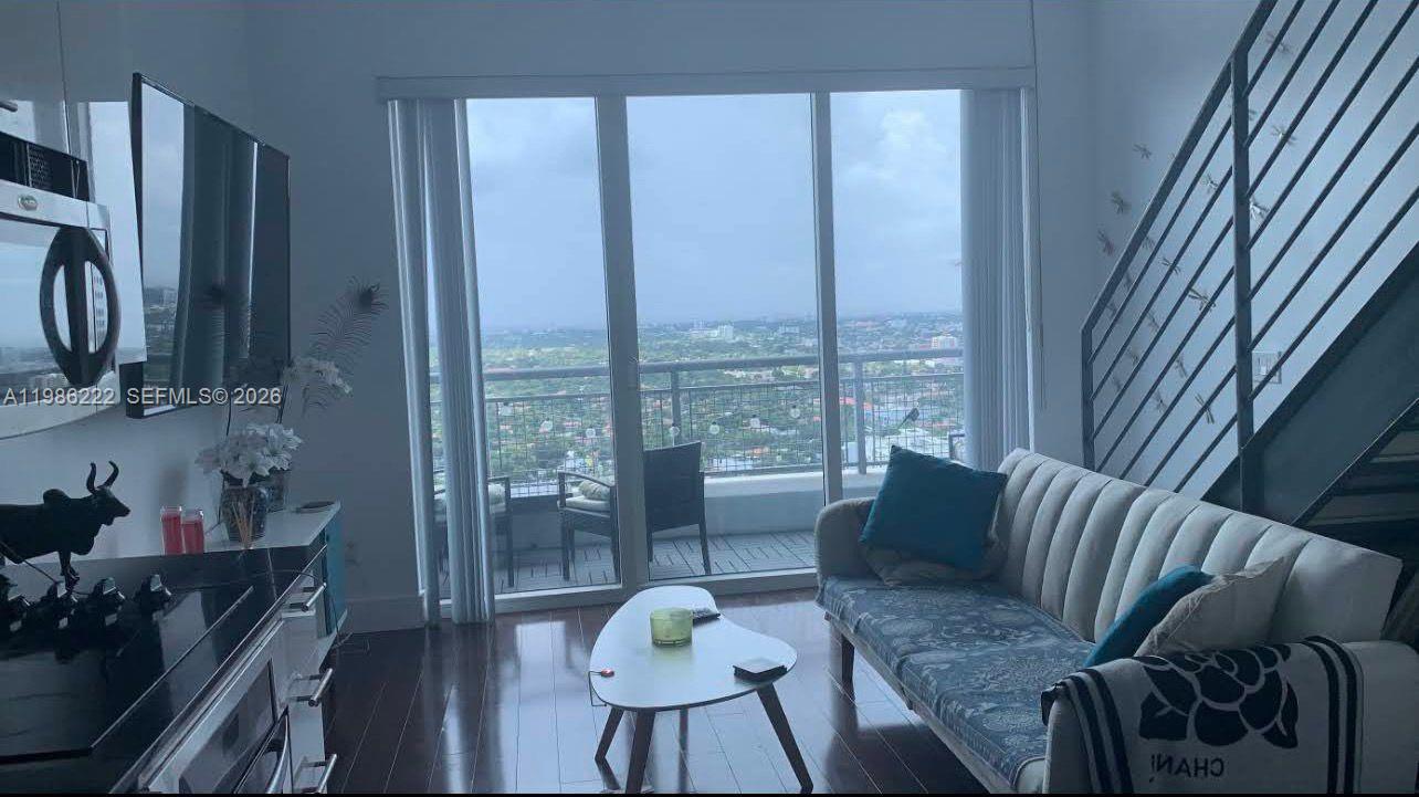 60 Southwest 13th Street, Unit 3017 Miami, FL 33130 - Photo 20 of 46 a living room with furniture and a large window