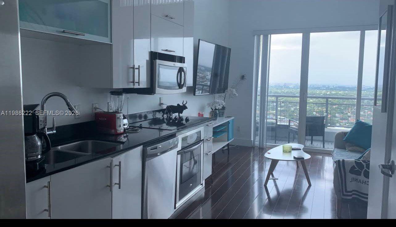 60 Southwest 13th Street, Unit 3017 Miami, FL 33130 - Photo 22 of 46 a kitchen with a sink cabinets and dining table