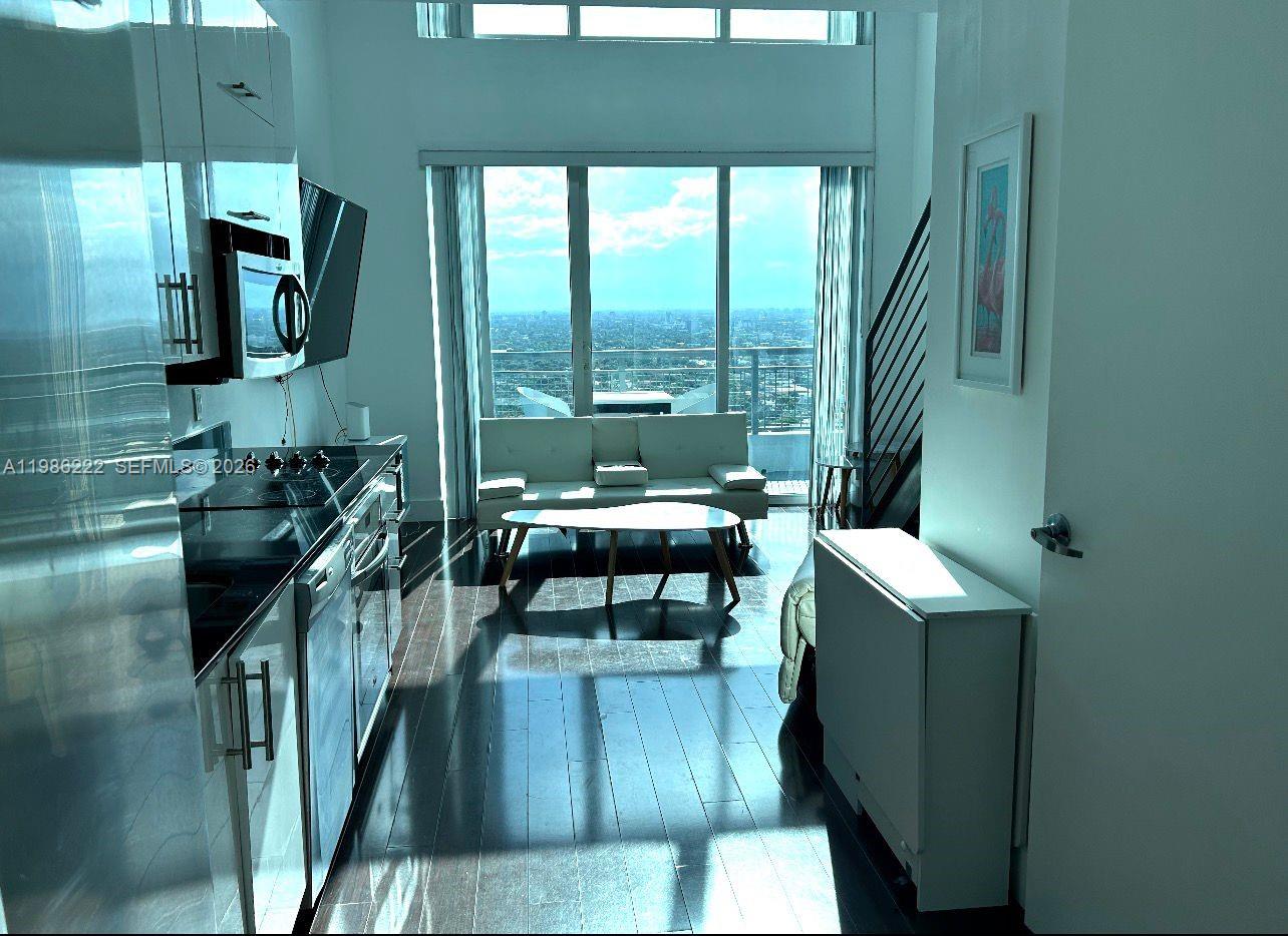 60 Southwest 13th Street, Unit 3017 Miami, FL 33130 - Photo 25 of 46 a living room with furniture and a floor to ceiling window