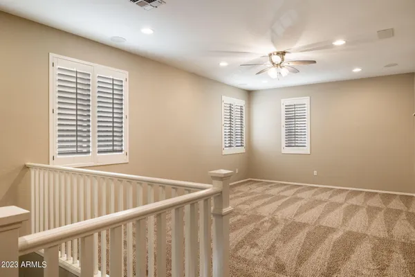 an empty room with a window and a ceiling fan