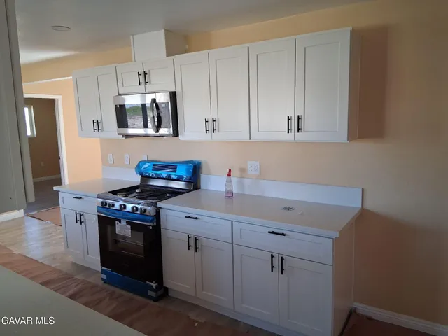 a kitchen with stainless steel appliances a stove a sink and cabinets