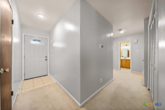 a view of a hallway with wooden shelves