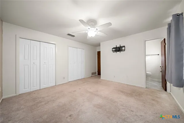 a view of an empty room and a ceiling fan