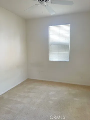 an empty room with wooden floor closet and windows