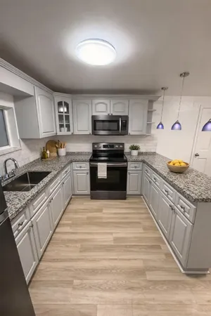 a large kitchen with stainless steel appliances granite countertop a stove and a sink