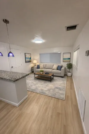 a living room with furniture and a wooden floor
