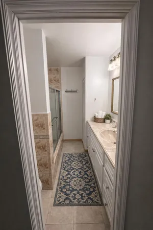 a bathroom with a granite countertop shower a sink and a mirror