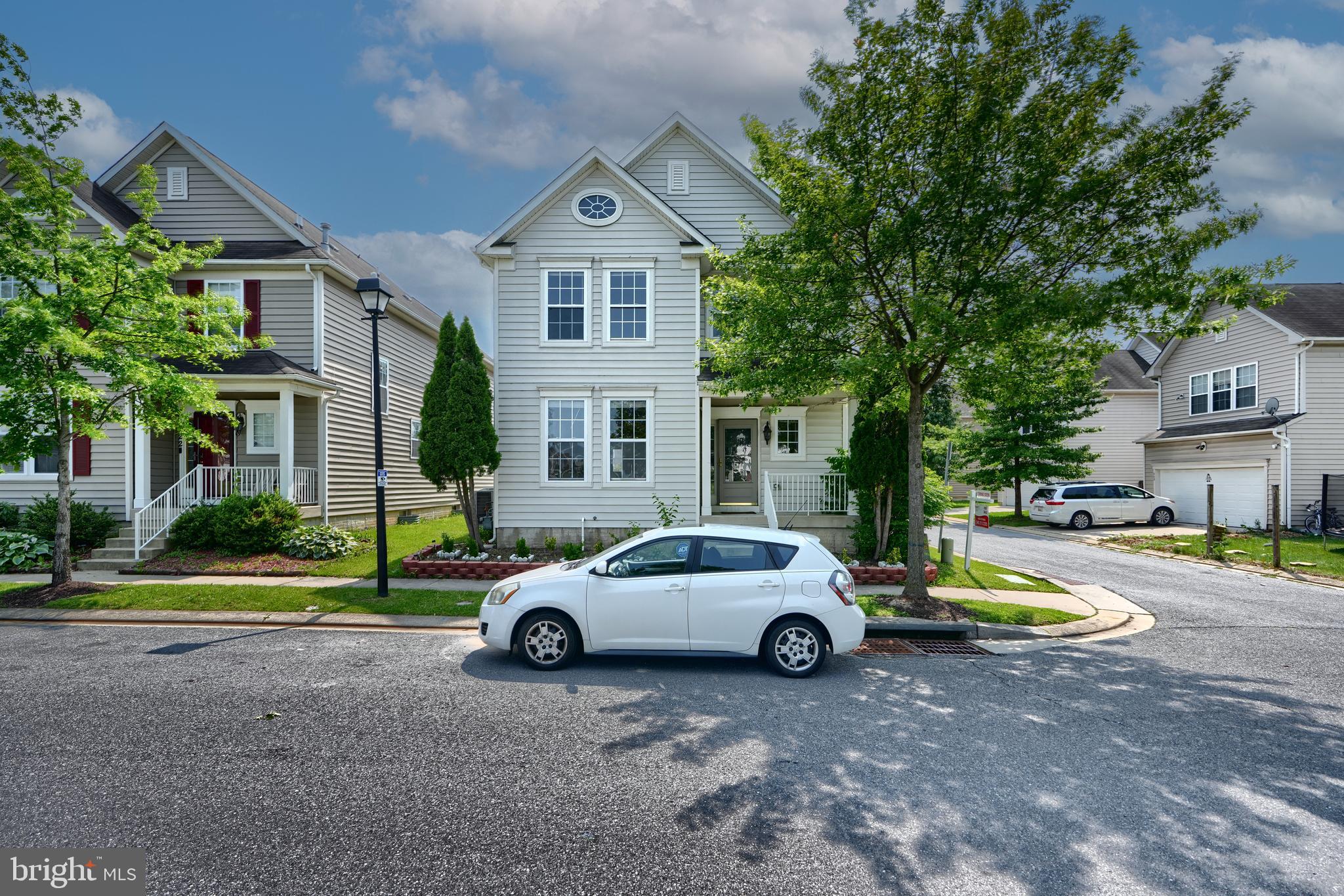 a car parked in front of a house next to a yard