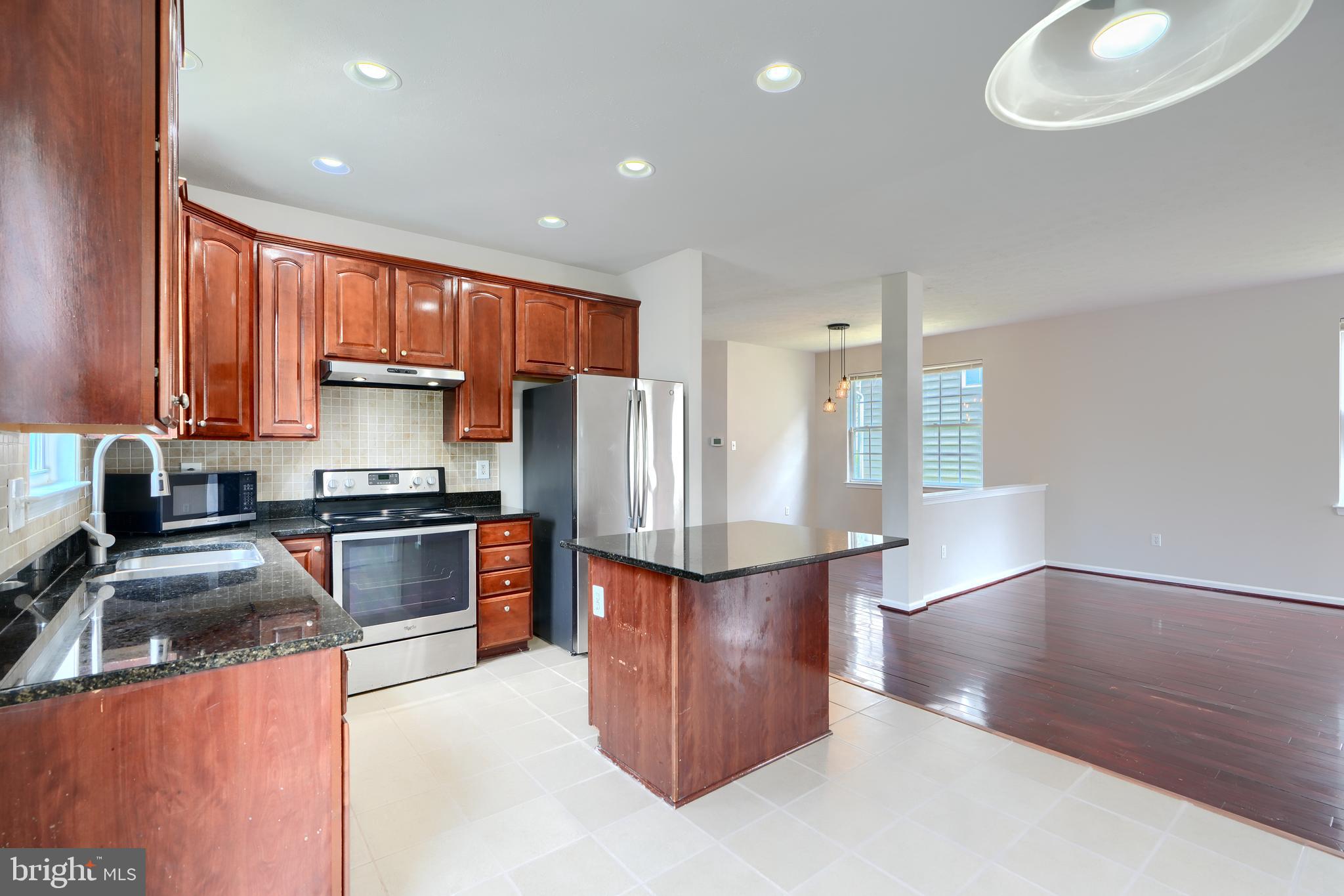 724 Tinker Road Middle River, MD 21220 - Photo 14 of 68 a kitchen with stainless steel appliances granite countertop a refrigerator a sink dishwasher a stove and oven with wooden floor