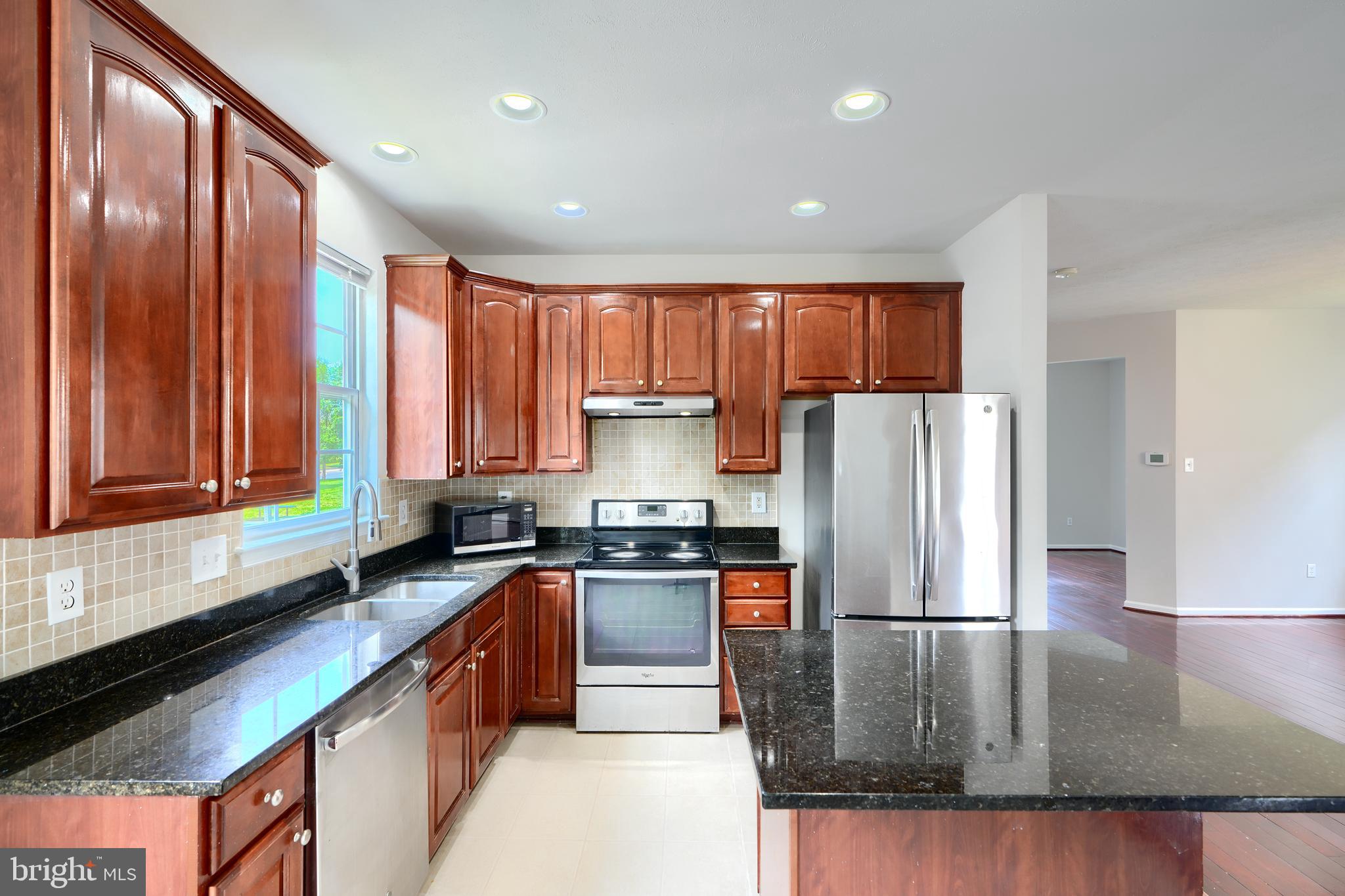 724 Tinker Road Middle River, MD 21220 - Photo 15 of 68 a kitchen with kitchen island granite countertop a stove sink refrigerator and cabinets