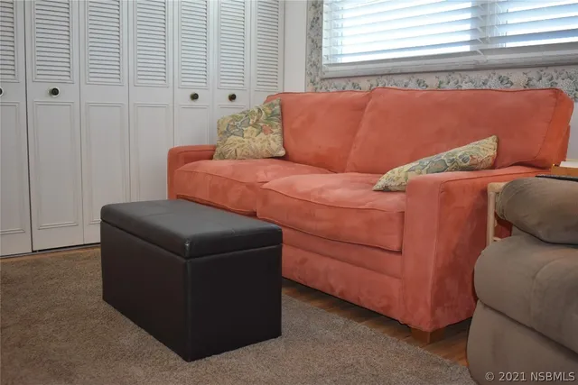 a couch sitting in a bedroom next to a window