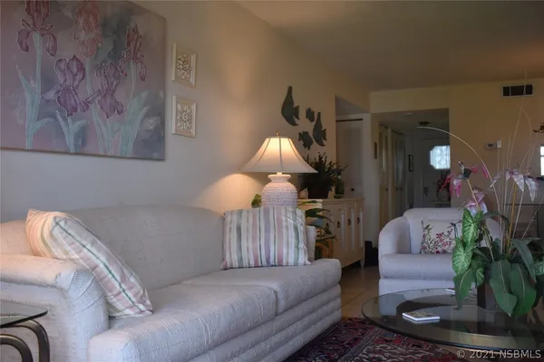 a living room with furniture flowerpot and a lamp