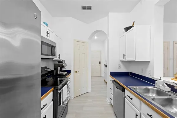 a kitchen with stainless steel appliances a sink stove and cabinets