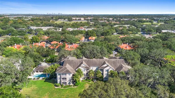 an aerial view of residential houses with outdoor space and trees