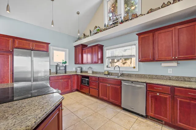 a kitchen with stainless steel appliances granite countertop wooden cabinets a sink and dishwasher
