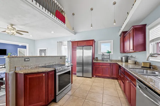 a kitchen with stainless steel appliances granite countertop a sink stove and refrigerator