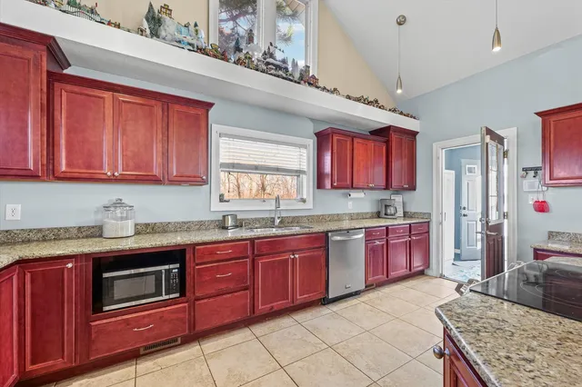 a kitchen with granite countertop stainless steel appliances a stove sink and microwave