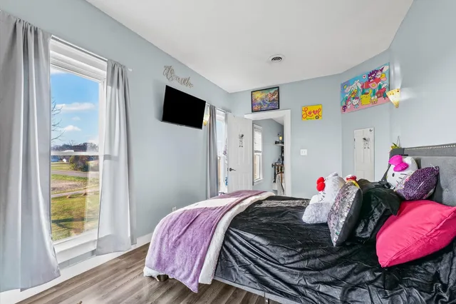 a bedroom with a bed and wooden floor