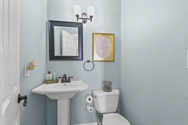 a bathroom with a toilet sink and mirror
