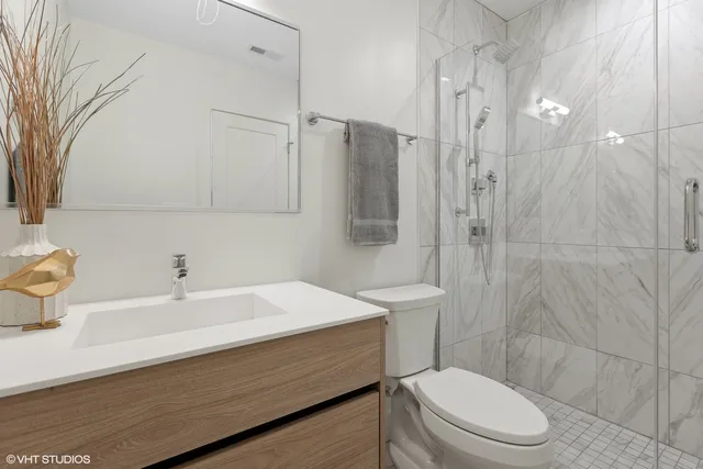 a bathroom with a sink a toilet and shower