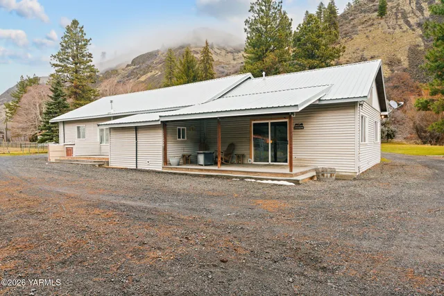 a view of a white house with a outdoor space and backyard