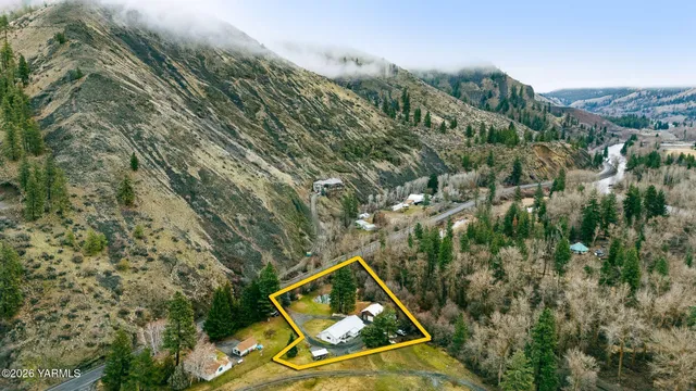 an aerial view of a house with a yard and street