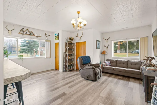 a living room with furniture a chandelier and a window
