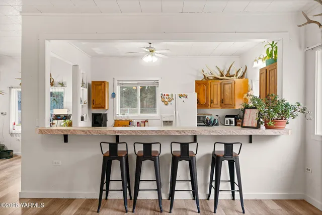 a kitchen with stainless steel appliances a table and chairs in it