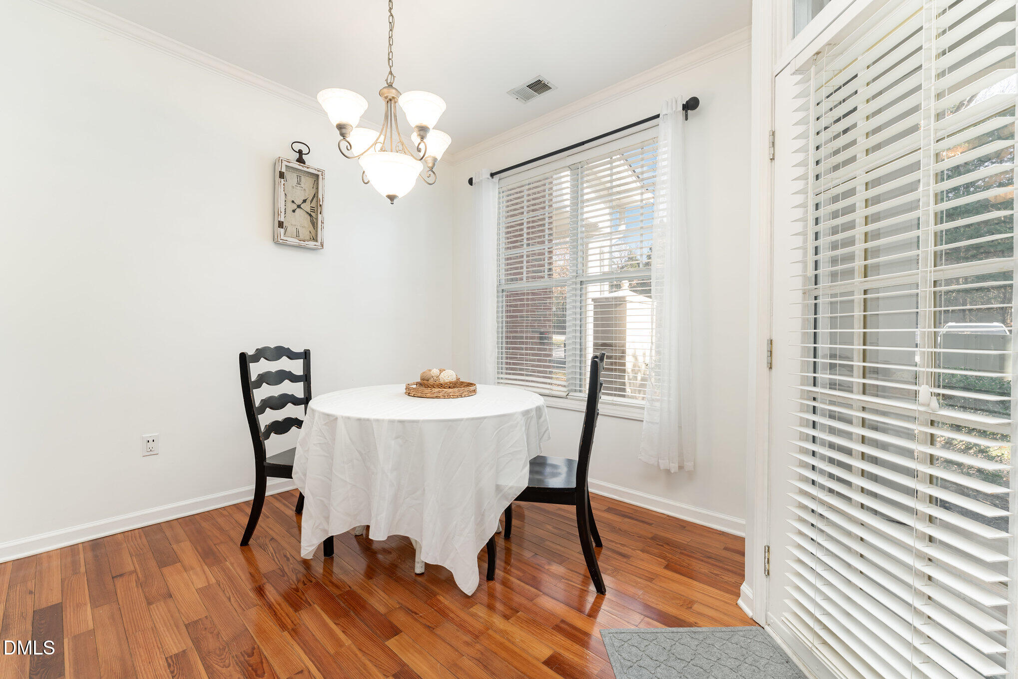 8231 Allyns Landing Way, Unit 101 Raleigh, NC 27615 - Photo 13 of 25 a view of a dining room with furniture wooden floor and chandelier