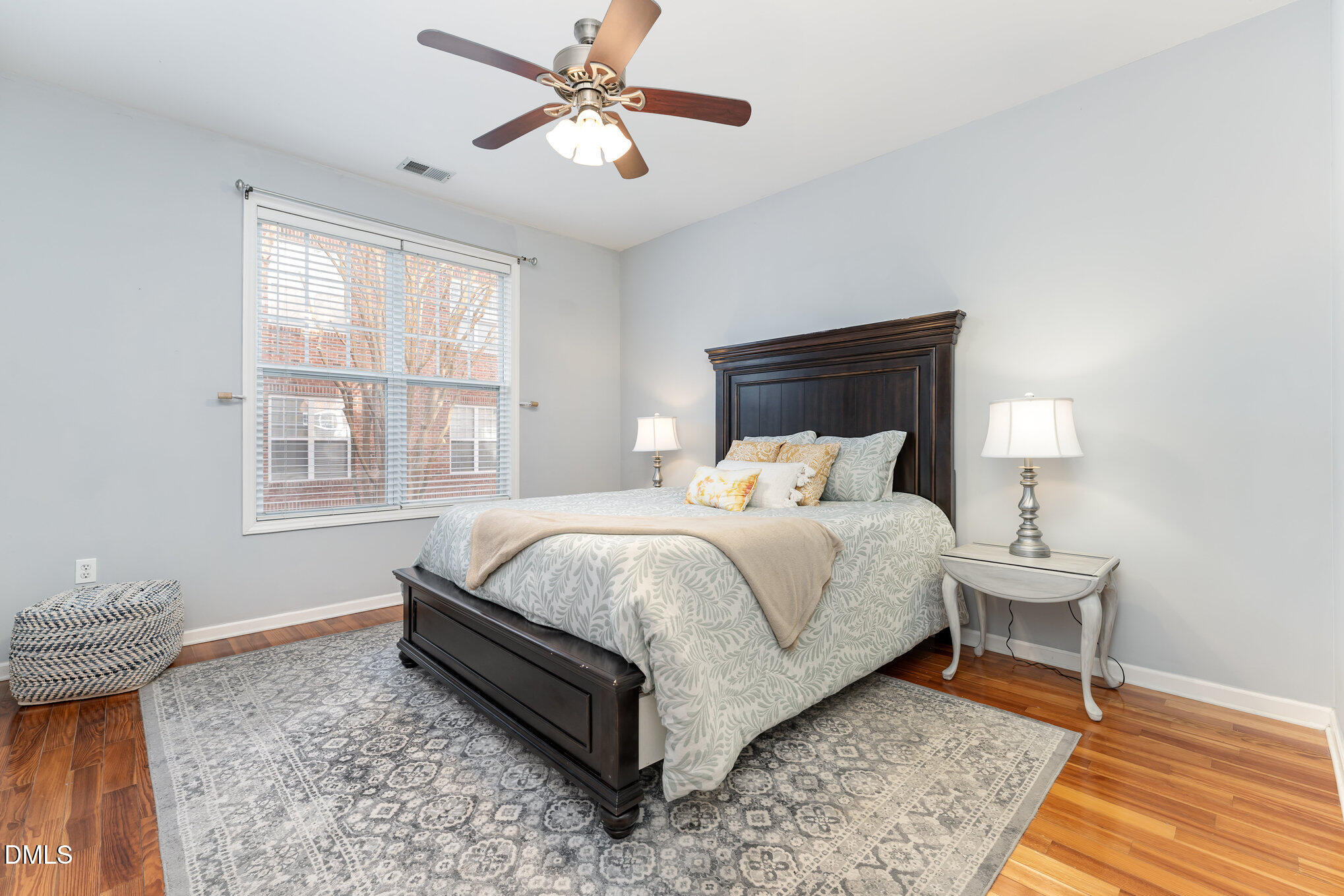 8231 Allyns Landing Way, Unit 101 Raleigh, NC 27615 - Photo 17 of 25 a bedroom with a bed and wooden floor