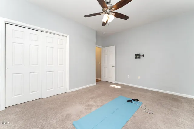 an empty room with chandelier fan