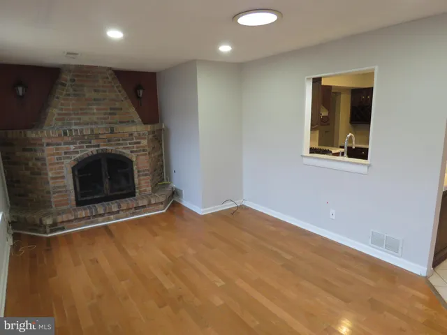 an empty room with wooden floor and fireplace