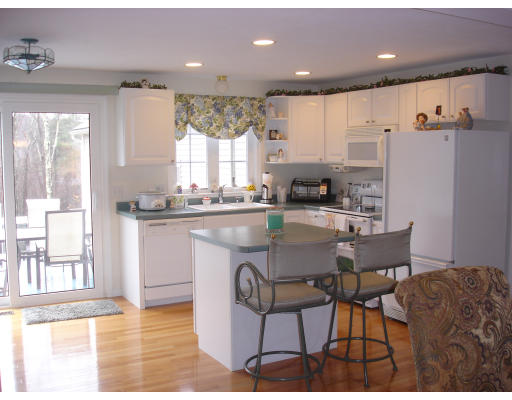 96 Mashapaug Road Sturbridge, MA 01566 - Photo 4 of 30 a kitchen with stainless steel appliances granite countertop a table chairs and a refrigerator