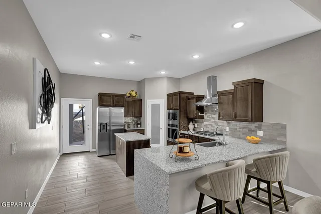 a kitchen with refrigerator and chairs