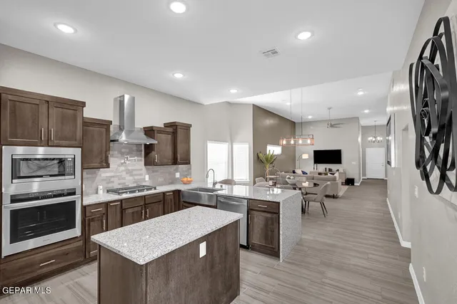 a large kitchen with lots of counter space a sink appliances and cabinets