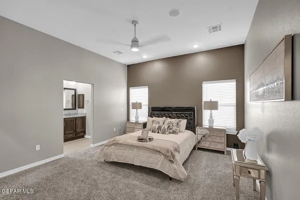 a bedroom with a large bed and a chandelier