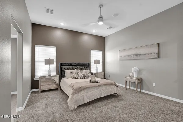 a bedroom with a large bed and a chandelier