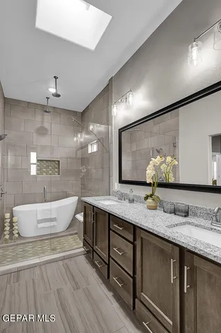 a bathroom with a granite countertop sink a large mirror and bathtub