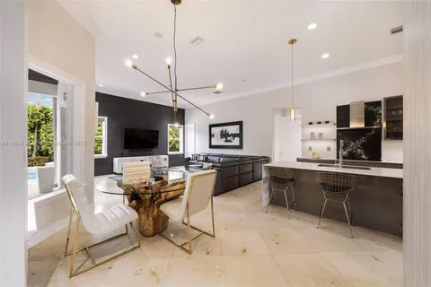 a living room with furniture a flat screen tv and kitchen view
