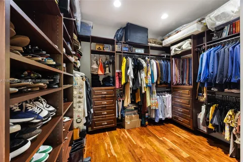a view of walk in closet with clothes and shoes