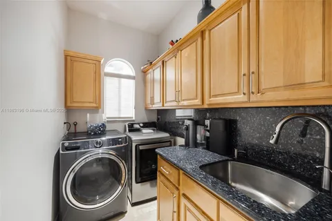 a kitchen with a sink a washer and dryer next to a window