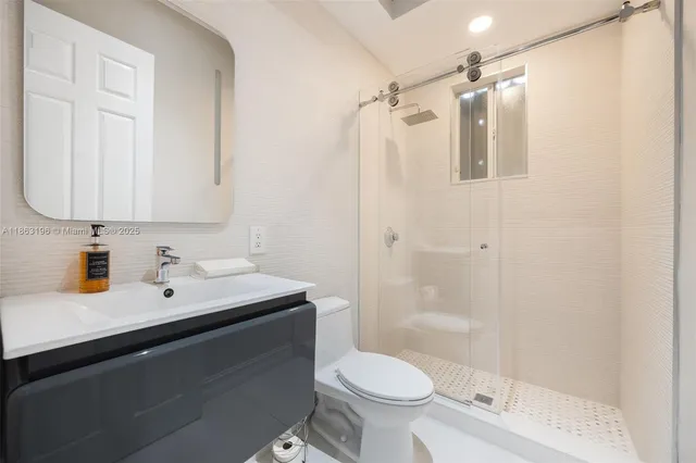 a bathroom with a sink toilet a mirror and shower