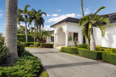 a front view of yellow house with a yard and a garage