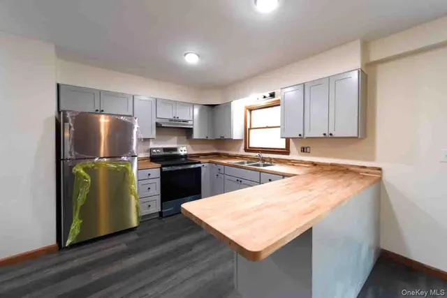 a kitchen with granite countertop a refrigerator stove top oven and sink