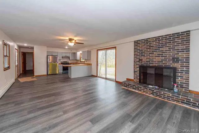 a view of a kitchen and a fireplace wooden floor and a kitchen